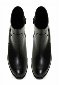 Mustad nahast pahklestebooted sileda viimistlusega, kumerate joontega, minimaalsete metalldetailidega ja külgsete tõmblukkudega lihtsaks selga panemiseks.