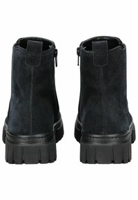 Bottines noires en daim avec une semelle en caoutchouc noir épaisse, dotées d'une fermeture éclair sur le côté et d'un talon renforcé pour plus de durabilité.