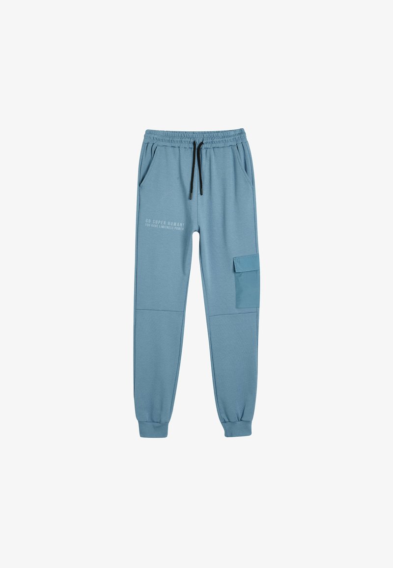 Lyseblå joggingbukser med elastisk talje, snøre, to sidelommer og en cargo-lomme, med trykt tekst på venstre ben.