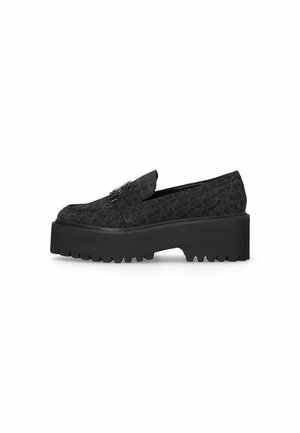 Mocassins à platforme noires avec un motif texturé et une semelle en caoutchouc épaisse. Comprend un rabat avec des détails de quincaillerie décoratifs.