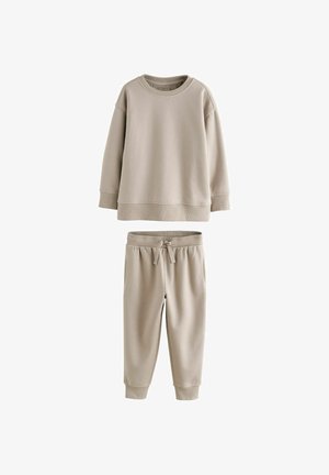 Ensemble de sweats en deux pièces de couleur beige clair comprenant un sweat à col ras du cou avec des poignets côtelés et un pantalon assorti avec cordon de serrage et taille élastique.