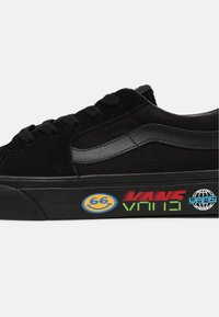 Black sneakers made of suede and textile, featuring a signature side stripe, textured black rubber sole, and colorful graphic accents.