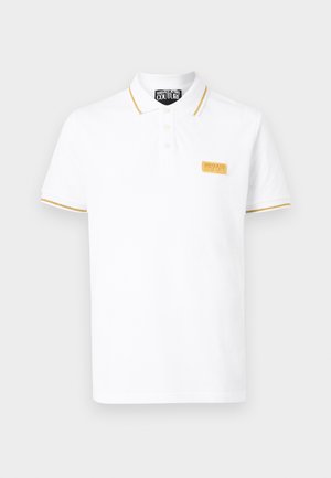 Balta Versace Jeans Couture polo krekls ar zelta apdari apkaklē un piedurknēs, kā arī zelta logotipa plāksteri uz krūtīm.