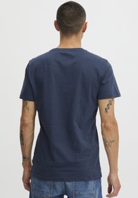 Marineblå bomull T-skjorte med rund hals og korte ermer, med en glatt tekstur og minimalistisk design.