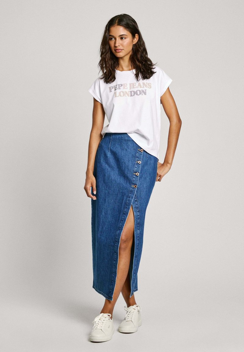 Bílé tričko s krátkým rukávem s potiskem "PEPE JEANS LONDON", spárované s džínovou sukní ke kolenům s knoflíky a bočním rozparkem. Bílé tenisky.