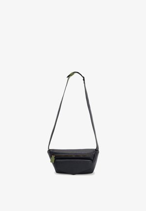 Zwarte crossbodytas van getextureerd leer met voorklepzak, gouden rits, groene ritstrekker en verstelbare band op witte achtergrond.