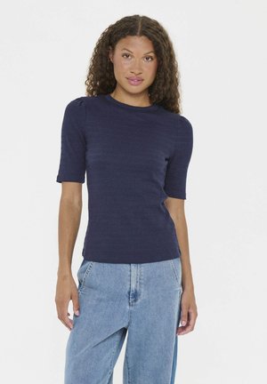 Maglietta a maniche corte blu navy con texture a costine e scollatura a girocollo, abbinata a jeans azzurri a vita alta.
