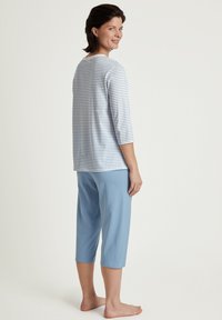 Light blue striped long-sleeve shirt with a round neckline, paired with solid light blue cropped pants. Soft fabric, relaxed fit.