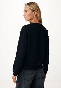 Schwarzes Sweatshirt mit Rundhalsausschnitt, gerippten Bündchen und Saum. Hergestellt aus weichem Stoff, bietet eine entspannte Passform und minimale Designdetails.