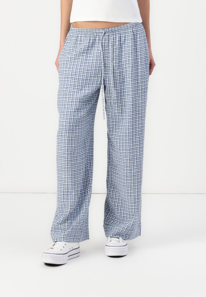 Pantalons de lounge en coton à carreaux bleus et blancs avec une taille élastique et un cordon de serrage. Avec des poches latérales et une coupe décontractée et droite.
