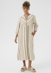 Robe maxi rayée avec un décolleté en V, présentant des motifs pastel vert, rose et noir, ainsi que des poches latérales. Fabriquée en tissu léger.