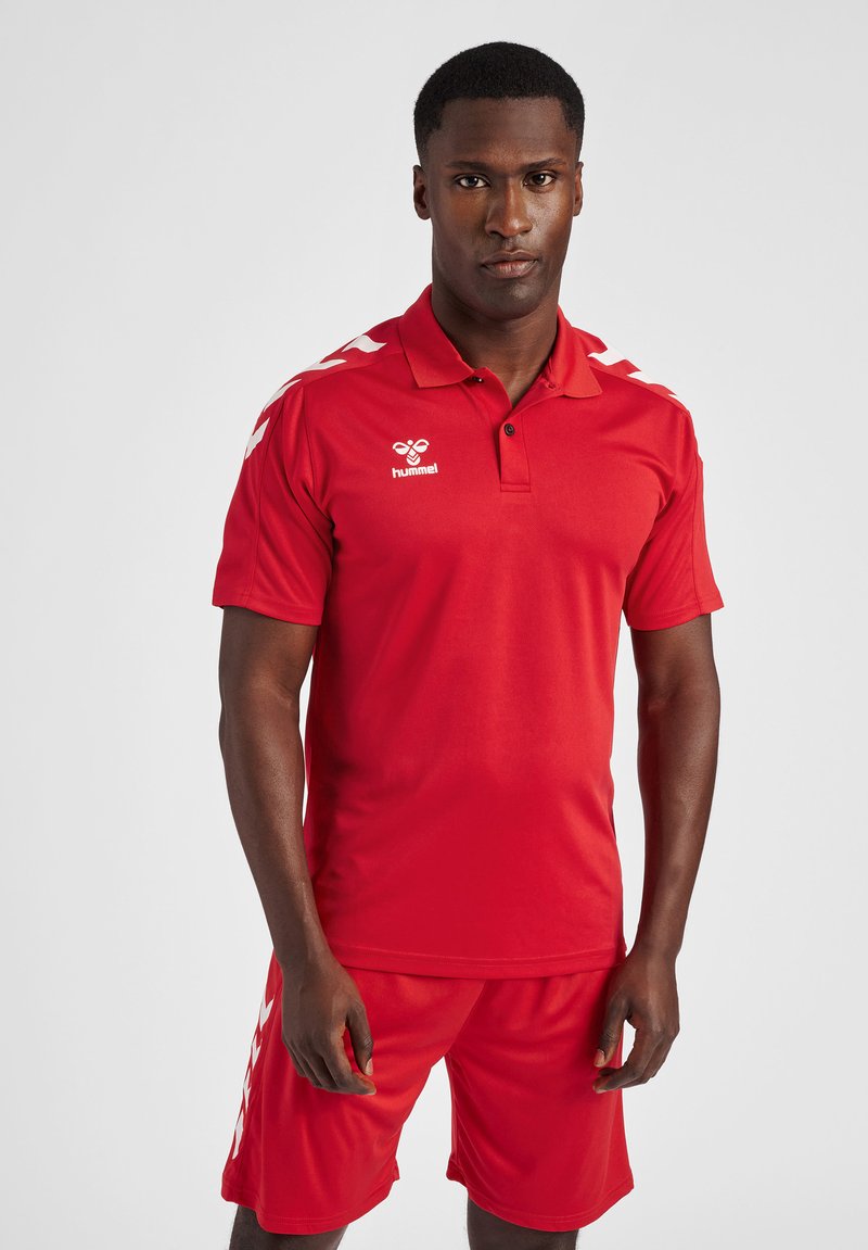 Rode sportieve polo en short set gemaakt van vochtregulerende stof. Beschikt over een kraag en witte branding, met contrasterende schouderstrepen.