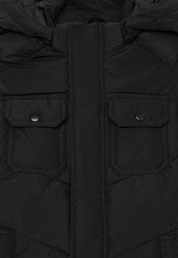 Čierna nafúknutá bunda s rozopínaním na zips, dvoma prednými vreckami so zapínaním na cvoky a kapucňou. Materiál je hladký a izolovaný.