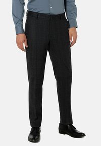 Schwarze karierten Anzughosen aus strukturiertem Stoff, mit schmaler Passform und Gürtelschlaufen, kombiniert mit schwarzen Lederschuhen.