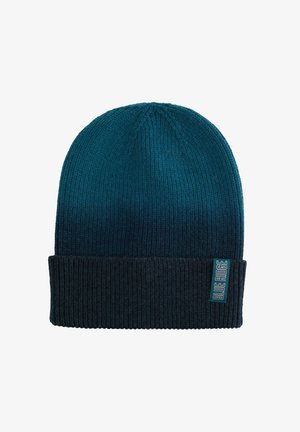 Kootud beanie, millel on gradient värv alates teal'ist ülaosas kuni tumeda mereväe värvini allosas. Omab ribade tekstuuri ja õmmeldud logo silti.