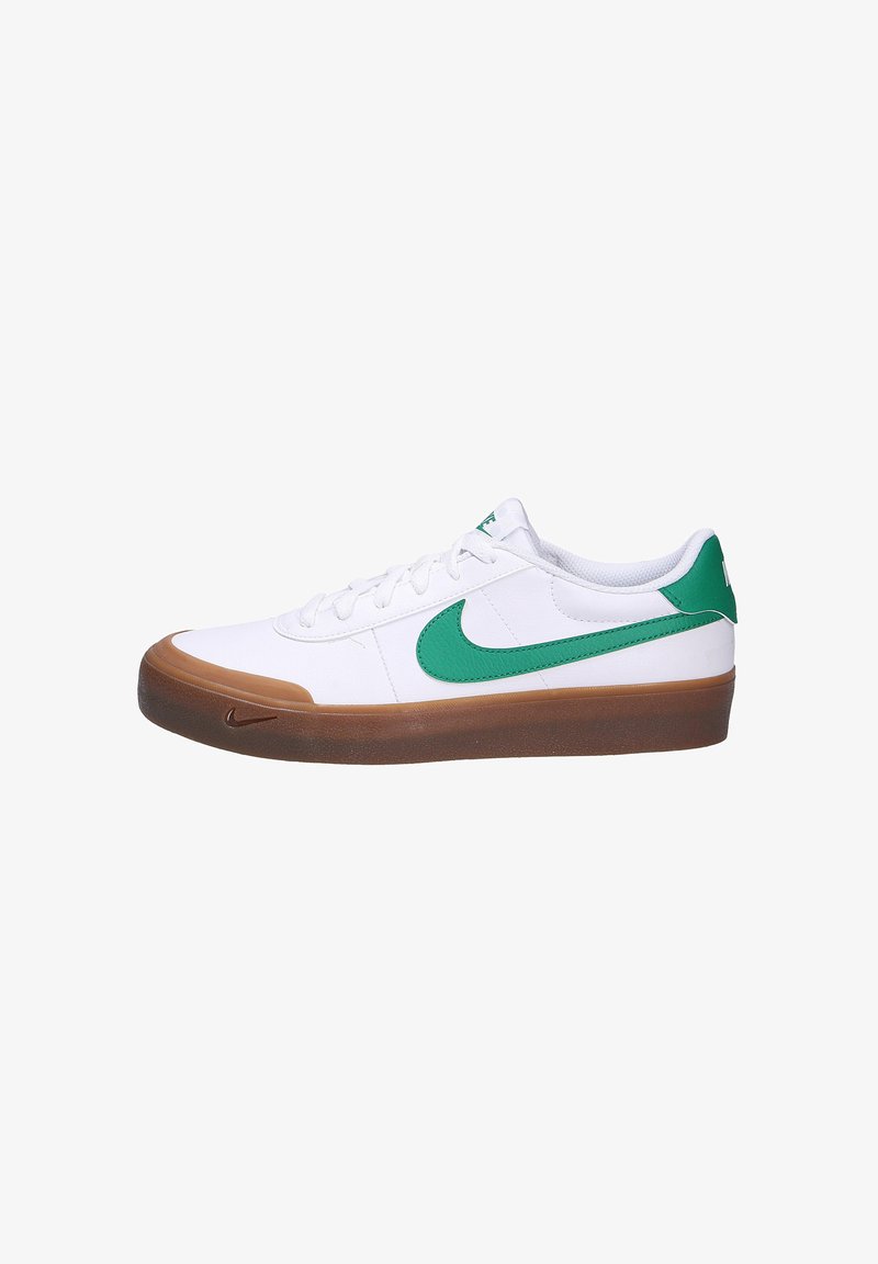 Witte sneaker met groene accenten, voorzien van een rubberen gum zool, textuurcanvas bovenwerk en centrale vetersluiting. Het Nike-logo is zichtbaar aan de zijkant.
