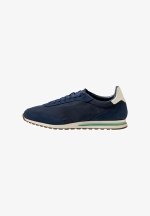 Scarpa da ginnastica blu navy realizzata in materiali misti, con tomaia in camoscio, lacci piatti e un accento verde chiaro sulla suola.
