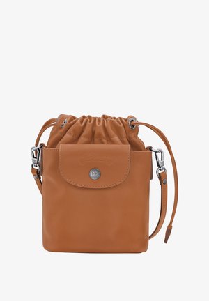 Helle Leder-Eimer-Tasche mit Zugverschluss, Vordertasche, silbernen Hardware-Details und verstellbarem Riemen. Texturierte Oberfläche. Quadratförmig.