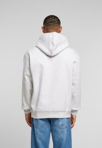 Hellgrau Kapuzenpullover mit großer Kapuze, aus weichem Baumwollmix gefertigt. Mit gerippten Bündchen und Saum, lässiger Passform und minimalen Nähten.