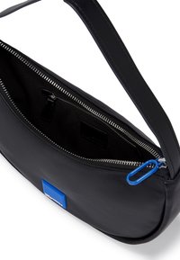 Black leather shoulder bag with a rounded shape, zip closure, and interior zip pocket. Features a blue accent patch and blue zipper pull.