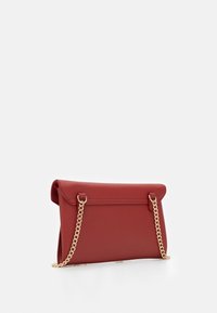 Borsa a pochette rossa in pelle con tracolla in oro, dotata di un design a patta pieghevole e una superficie testurizzata. Accenti in metallo dorato.