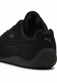 Sort Puma ruskinds sneakers med en tekstureret overflade, afrundet hæl, gummisål med mønster og subtilt logo.