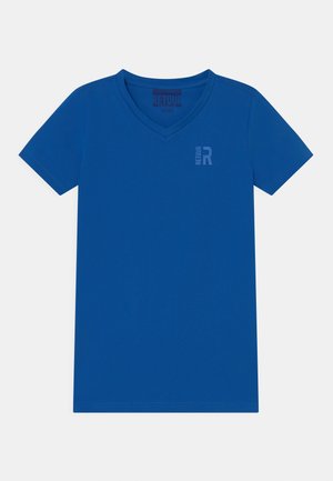 Camiseta azul de manga corta con cuello en V y un pequeño logo vertical "RETOUR R" en el lado izquierdo superior del pecho.