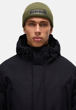 Black insulated jacket with high collar, drawstring, and textured olive green knit beanie with black logo patch.