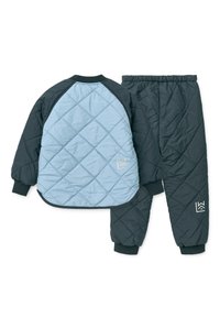 Σετ δύο τεμαχίων με επένδυση σε ανοιχτό μπλε και σκούρο γκρι. Το σακάκι διαθέτει σχέδιο διαμαντένιου καπιτονέ με ριμπ μανσέτες, και οι αντίστοιχες παντελόνες έχουν ελαστική ζώνη μέσης.