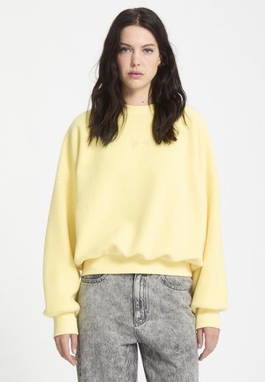 Gelber, weicher Fleece-Pullover mit rundem Ausschnitt und geripptem Saum. Verfügt über locker geschnittene lange �Ärmel und subtile gestickte Details.