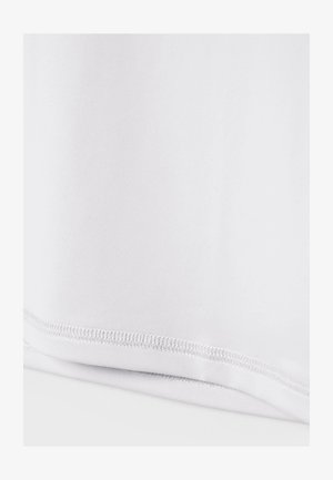 Gros plan d'un ourlet en tissu blanc avec une double couture soignée et un bord plié sur un fond blanc uni.