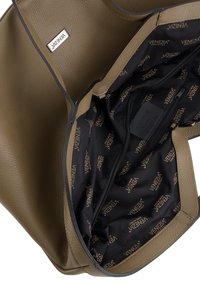 Intérieur d'un sac à main en cuir kaki présentant une finition texturée, une poche zippée et un revêtement de marque avec le logo "Venezia" répété en noir.