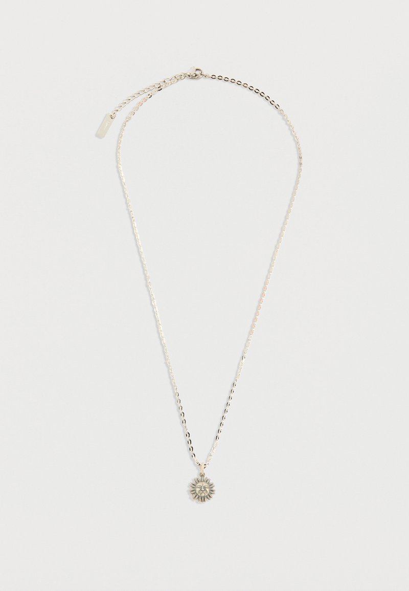 Ασημένιο κολιέ με αλυσίδα και μενταγιόν σε σχήμα ήλιου με λεπτομερειακό σχέδιο προσώπου, τοποθετημένο επίπεδα σε λευκό φόντο.