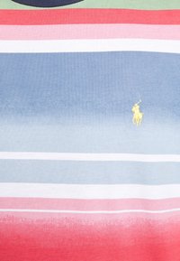 Wielokolorowa koszulka polo z poziomymi paskami w kolorach zielonym, czerwonym, różowym, białym, niebieskim oraz z małym emblematem polo w kolorze żółtym. Teksturowana tkanina.