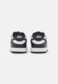 Nike-Schuhe mit einem Obermaterial aus schwarzem Leder, weißen Mesh-Akzenten und einer strukturierten Gummisohle. Mit Logo auf der Ferse und kontrastierenden Nähten.