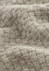 Beige knitted fabric with a herringbone pattern, featuring a soft, textured surface and subtle, varying thread thicknesses.