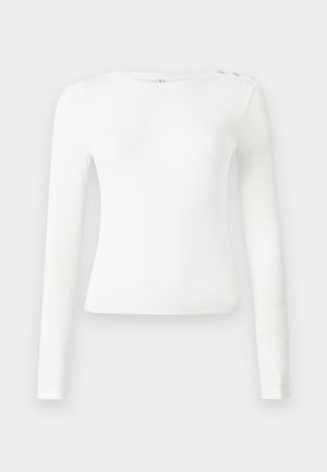 Witte top met lange mouwen, ribbelstructuur, ronde halslijn en drie decoratieve knopen op de linkerschouder. Gladde stof, aansluitende pasvorm.