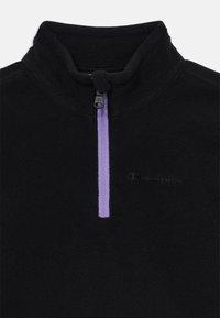 Pullover in pile nero con zip a quarto di pollice viola e piccolo logo Champion ricamato sul lato sinistro del petto.
