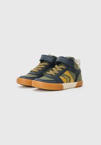 Høye sneakers i marineblått og olivengrønt, med en blanding av lær og stoff, og gule detaljer, snøring og justerbar stropp.