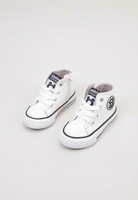 Zapatillas altas blancas con parte superior de cuero texturizado, detalles en negro, suela de goma blanca y cremallera lateral. Presenta un parche con el logo.