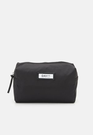 Black travel pouch made of durable fabric, featuring a zip closure, rectangular shape, and a label with “DAY ET” in white lettering.