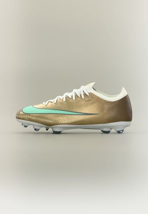 Goldener Fußballschuh mit weißen Schnürsenkeln, einem türkisen Nike-Swoosh und schwarzen Stollen auf weißer Sohle vor neutralem Hintergrund.