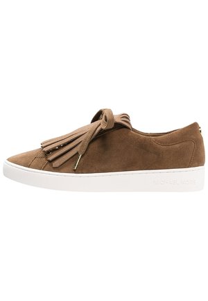 Brązowy zamszowy sneaker z białą podeszwą, sznurowaniem z przodu i ozdobnymi frędzlami na jednolitym białym tle.