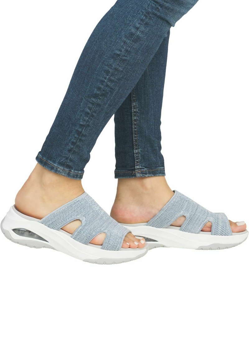 Ljusblå nätöppna sandaler med flera skärningar, vit vadderad sula och textilmaterial. Bärs med mörka jeans.