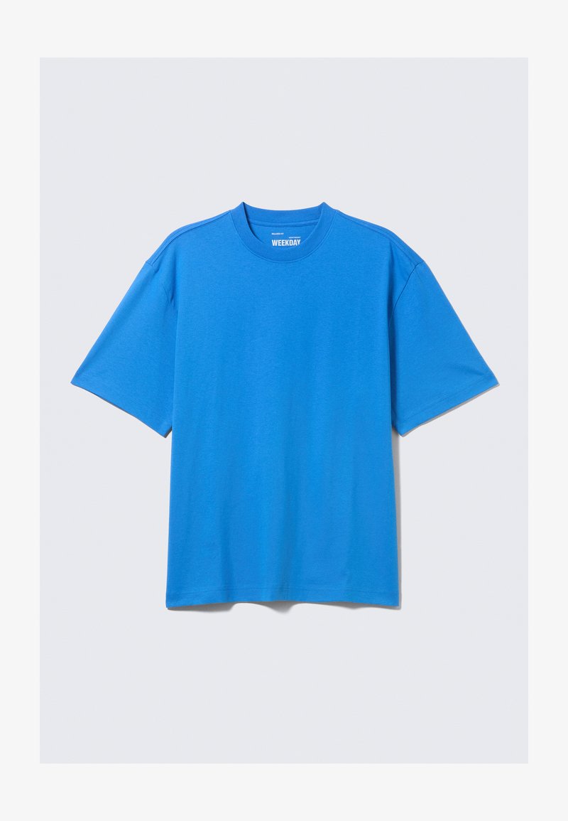 Φωτεινό μπλε κοντομάνικο T-shirt με στρογγυλή λαιμόκοψη και άνετη εφαρμογή, απλωμένο επίπεδα σε λευκό φόντο.