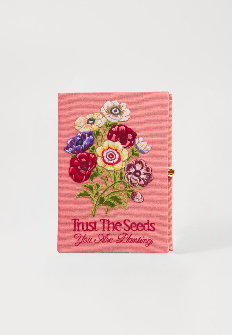 Caderno de tecido rosa com design floral bordado apresentando flores vermelhas, azuis e amarelas. O texto diz "Confia nas sementes que estás a plantar."