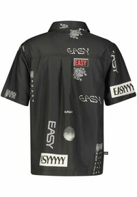 Chemise noire à manches courtes avec motifs cachemire blancs et divers textes "EASY" dans différentes polices et tailles sur le dos et les manches.