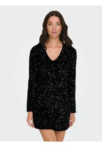 Czarna sukienka z cekinami, z dekoltem w serek, długimi rękawami i dopasowanym krojem. Tkanina ma teksturowaną, błyszczącą powierzchnię z błyszczącymi akcentami.
