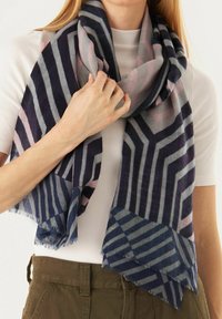 Écharpe géométrique avec des bandes navy, gris et rose poudré. Fabriquée en matériau doux avec des bords effilochés, drapée lâchement autour du cou.