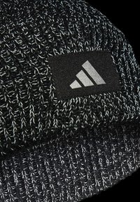 Gorro de malha preto com fios brancos, apresentando um retângulo preto na frente com um logo prateado de três riscas.